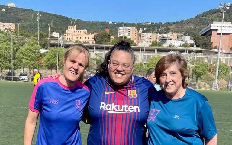 Tres jugadores somriuen juntes al camp