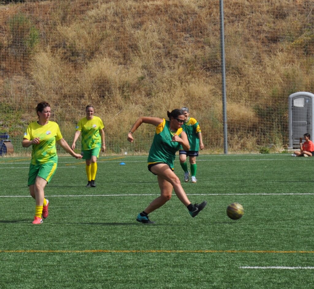 Una jugadora colpeja la pilota amb companyes d’equip al darrere